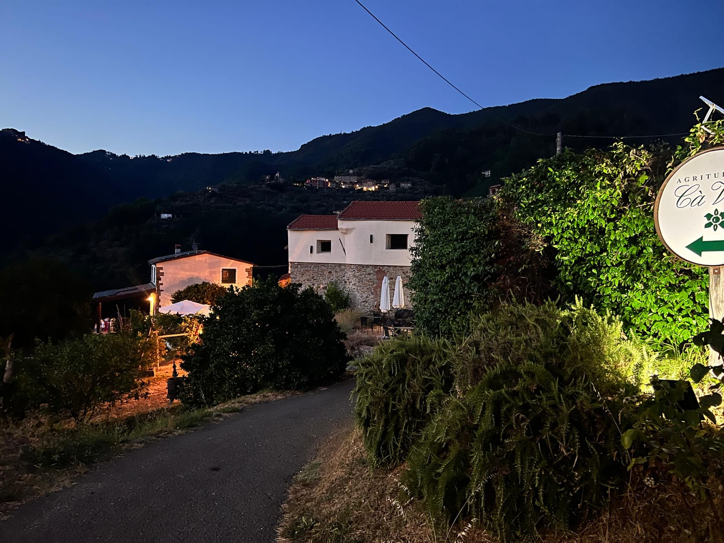 Il borgo di Caprognano con l’insegna dell’agriturismo Cà Vidè, all’ora blu